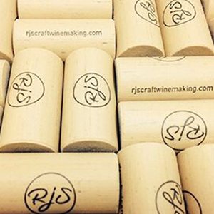 A heap of natural corks printed with the RJS logo and rjscraftwinemaking.com